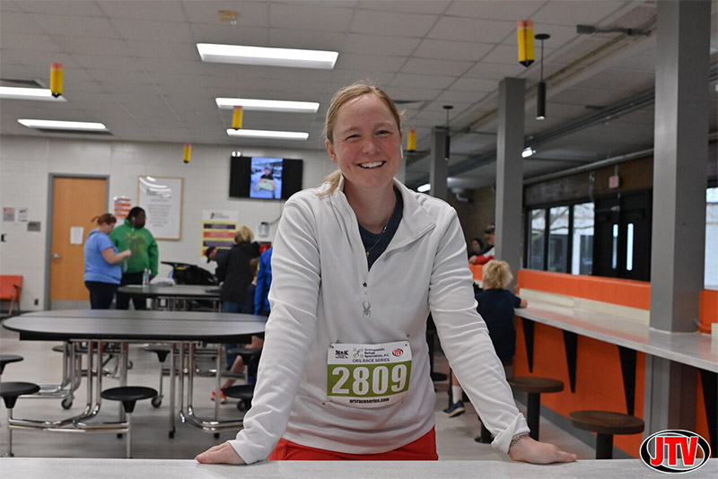 woman standing at a table before running the ORS Family Service and Children’s Aid 5k Run/Walk